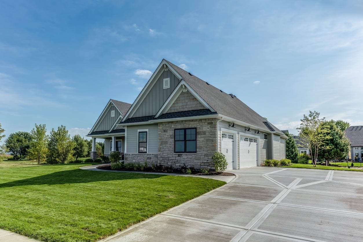 Home bordered by a green lawn and mature trees