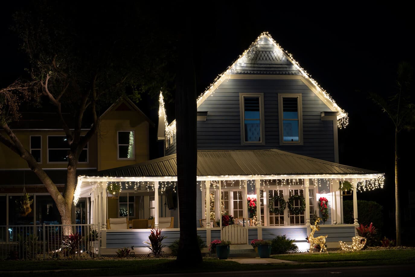 White holiday lights tracing the roof and porch of a house